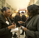 Two alumni networking at a Temple career event.