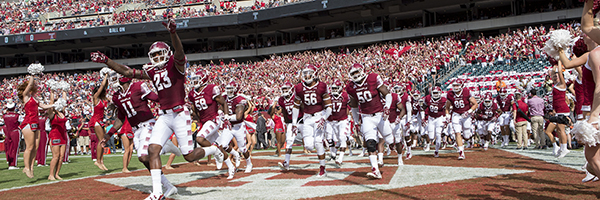Temple Football players running onto the field