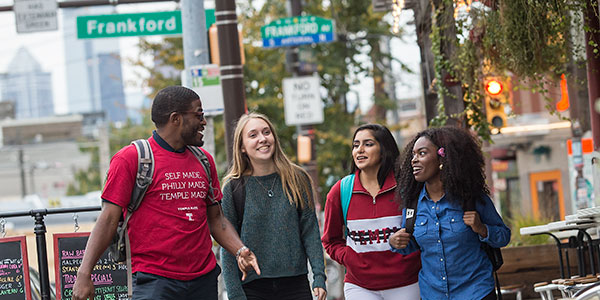 Four students walking on a sidewalk in Philadelphia.