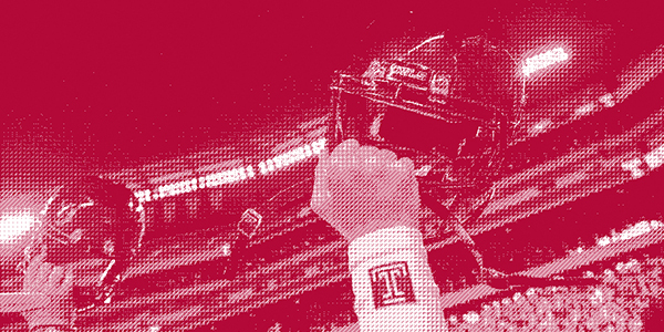 A red photo of Temple football players raising their fists.