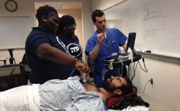 Two medical students showing middle school students a procedure in the hospital. 
