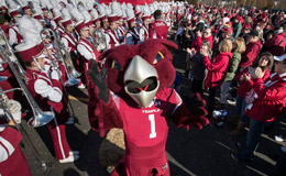 Temple mascot Hooter the Owl celebrating with the marching band and fans. 