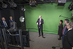A group of administrators looking at the green screen set up in the film studio. 
