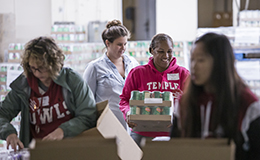Volunteers working together to package food.  
