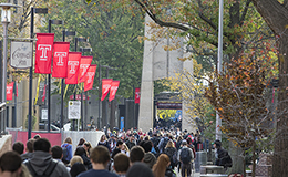 A crowd of students walking  on Polett Walk towards the Bell Tower.