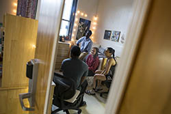 Several students sitting together in a residence hall room.