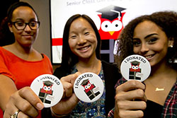Three students each holding a sticker that says “I donated.