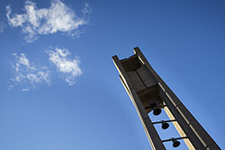 The Bell Tower and a bright blue sky with a few white clouds in the background.