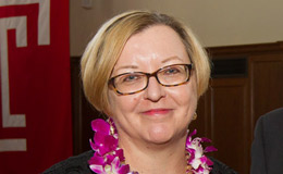 Elizabeth Bolman wearing a flower lei and smiling.