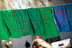 Green t-shirts with messages hanging from a clothesline in Founder’s Garden.