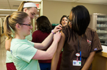 A member of the Flu Crew applies a bandage to an employee after a vaccination.