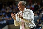 Coach Dunphy coaching from the sideline of a basketball court.