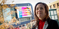 Jodi Laufgraben stands in front of a sign on Main Campus.