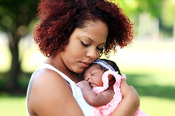 A mother holding a newborn baby girl.