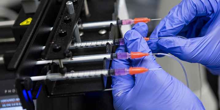 An engineering researcher adjusting vials.