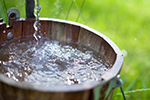 A bucket being filled with water from a well.